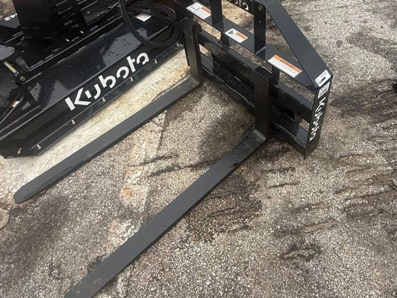 Kubota pallet forks attached to the front of the track loader.
