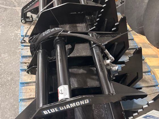 Blue Diamond root grapple attachment with toothed tines and hydraulic clamps, on a pallet.